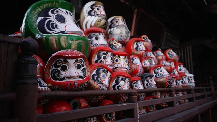 Rows of traditional daruma dolls displayed at a shrine