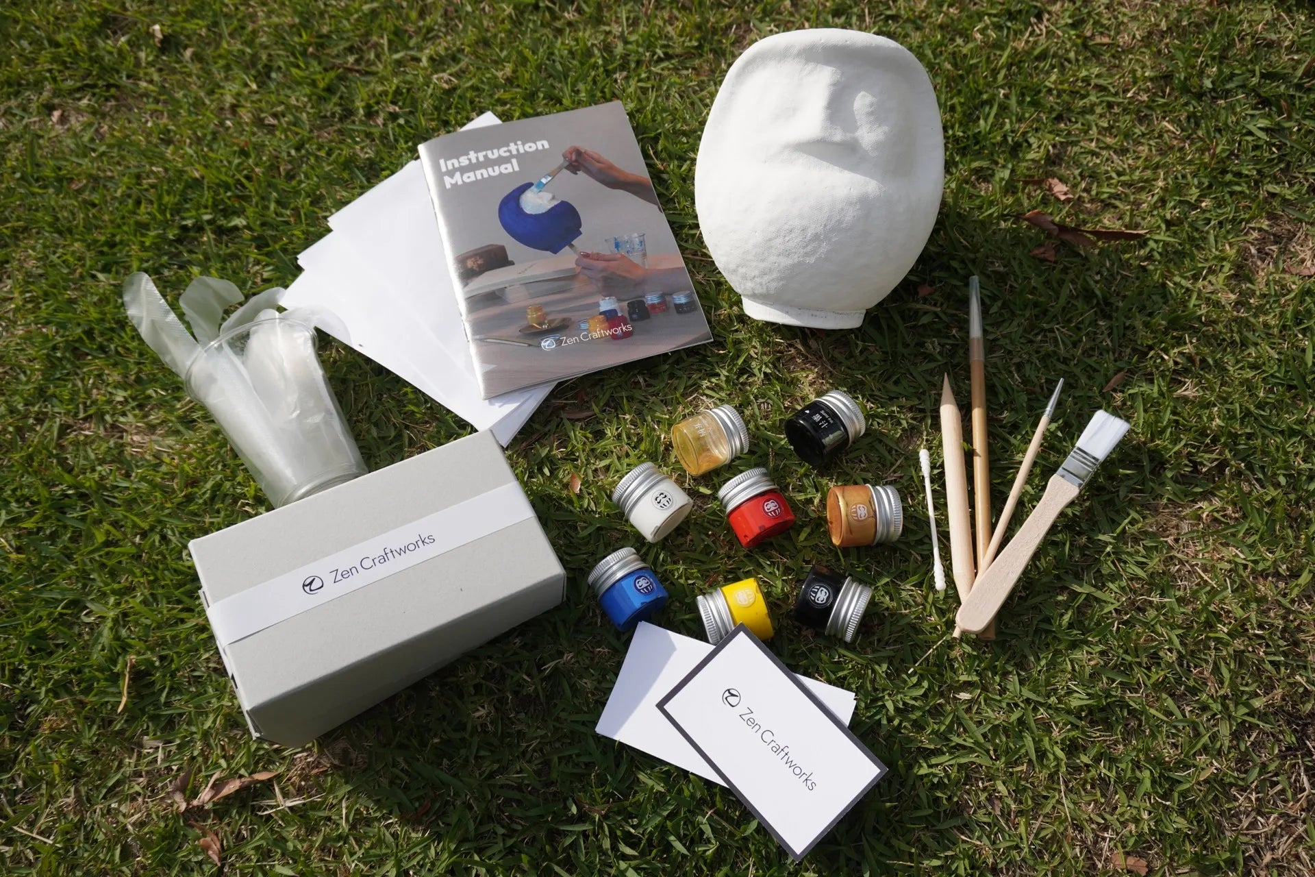 Daruma craft kit materials arranged on grass