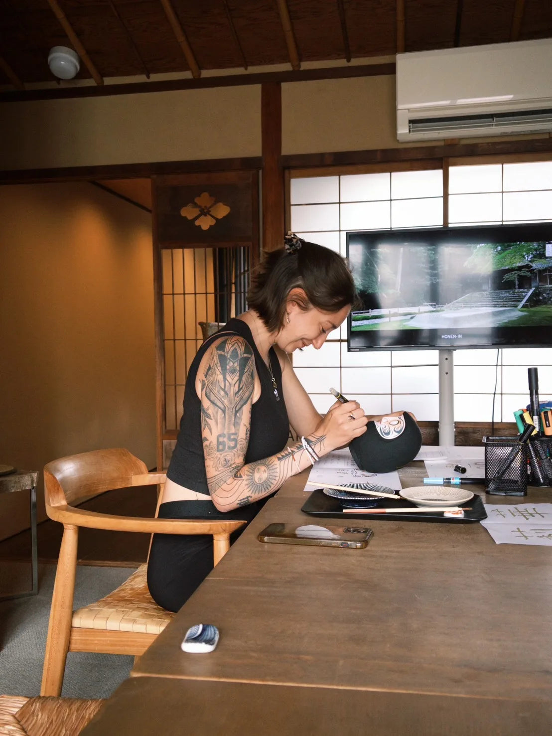 黒い高崎だるまに絵付けする参加者