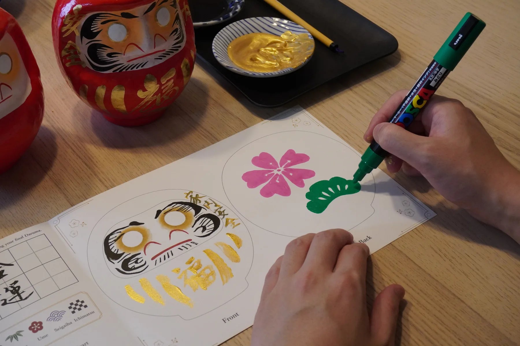 Planning decorations for a Takasaki Daruma with a design sheet