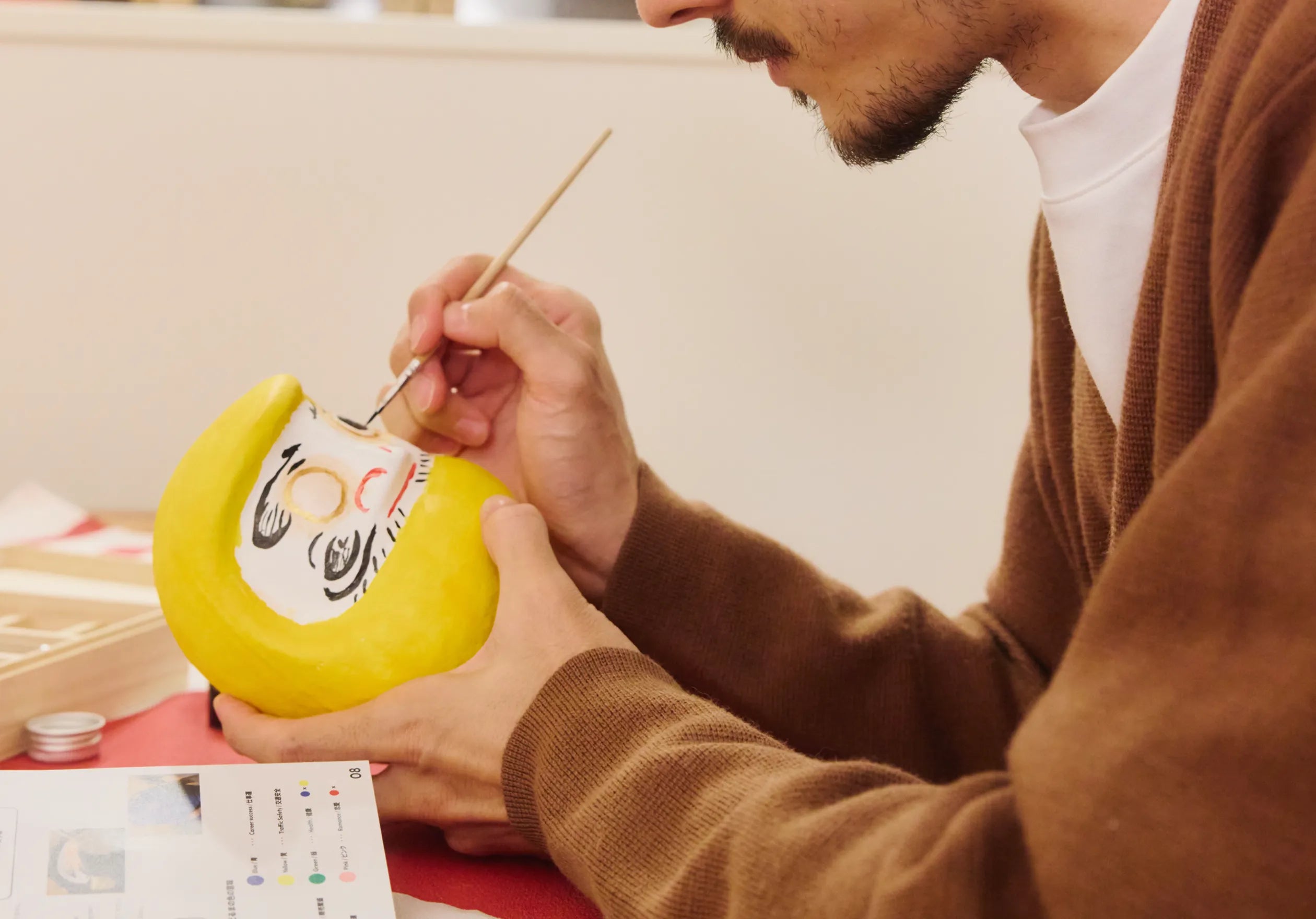 A guest painting one eye on a Daruma