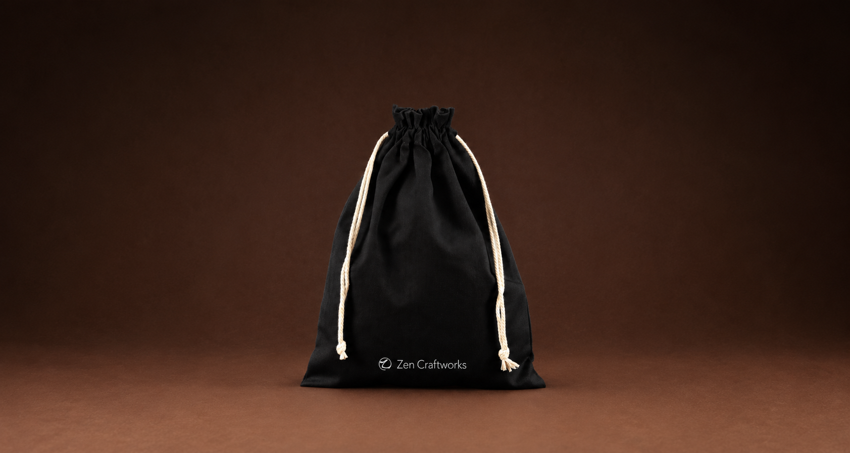 A ZEN CRAFTWORKS drawstring bag holding a finished Daruma