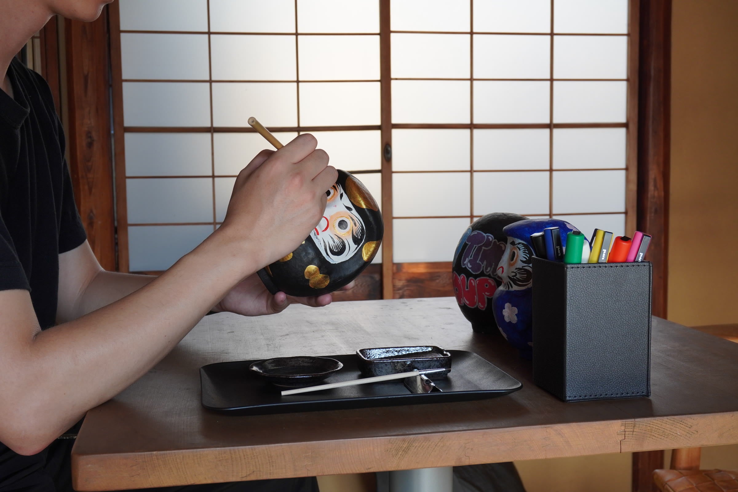 A guest painting a Takasaki Daruma at the Kyoto machiya venue